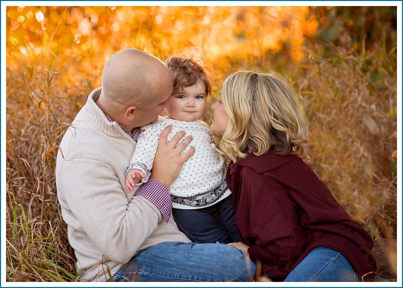 baby with parents in fall field