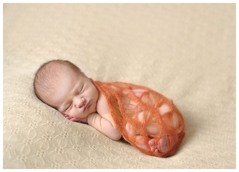 newborn in orange wrap