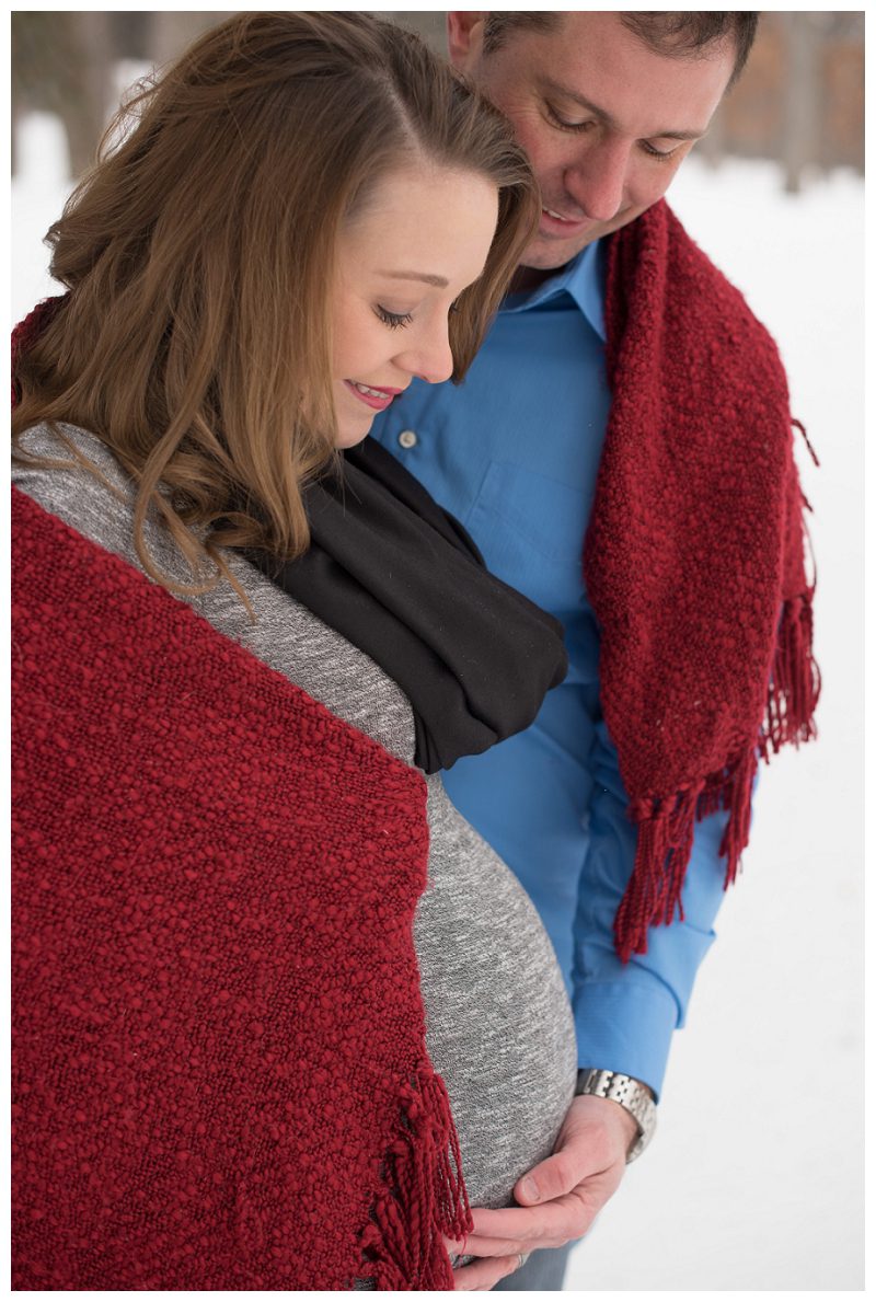 couples' maternity session in the snow with red blanket