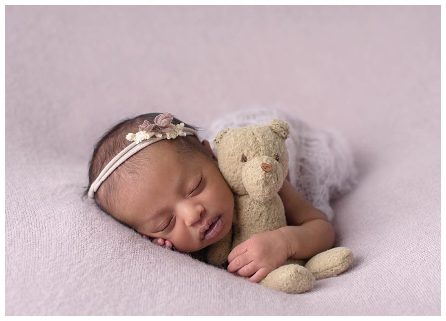 newborn baby with tiny teddy bear