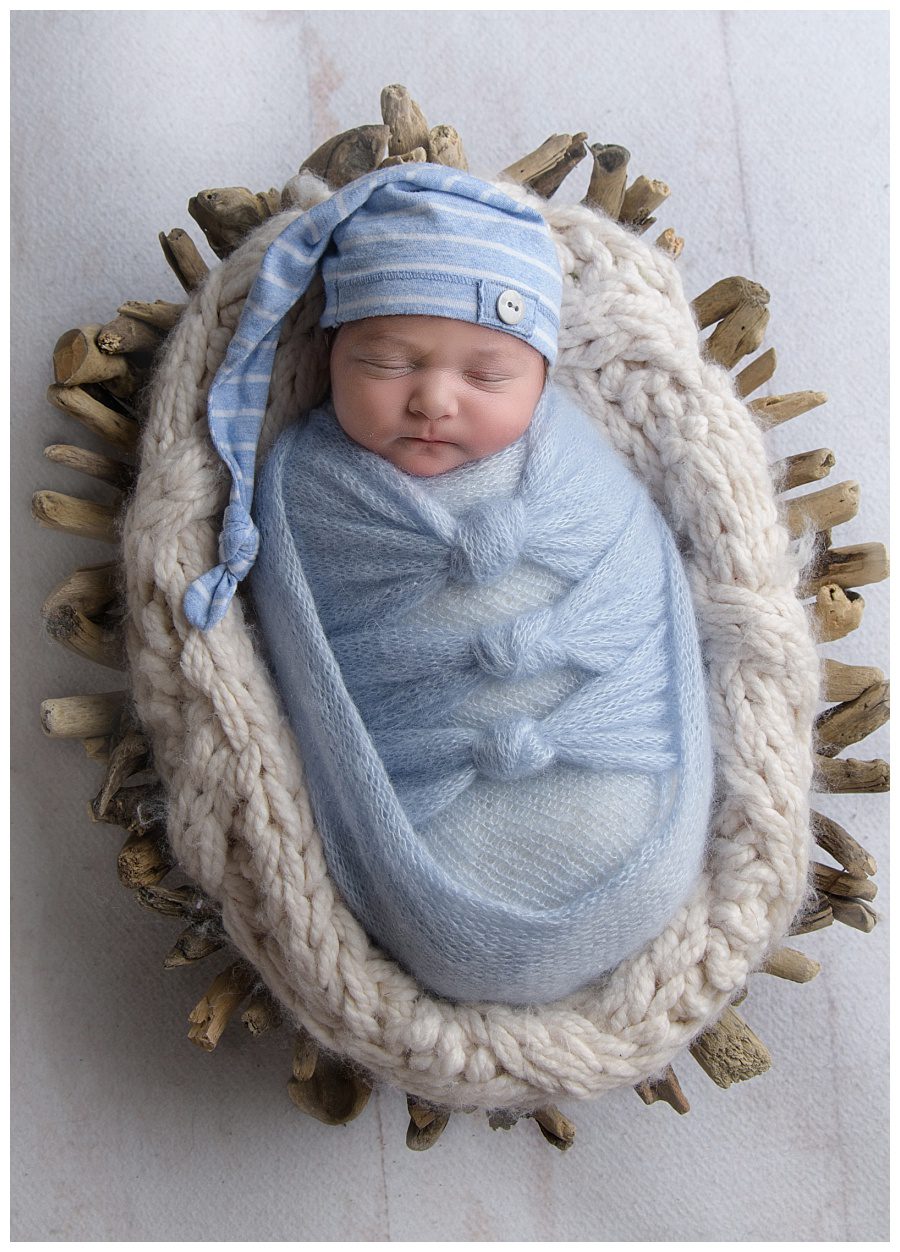 newborn in basket with stocking cap