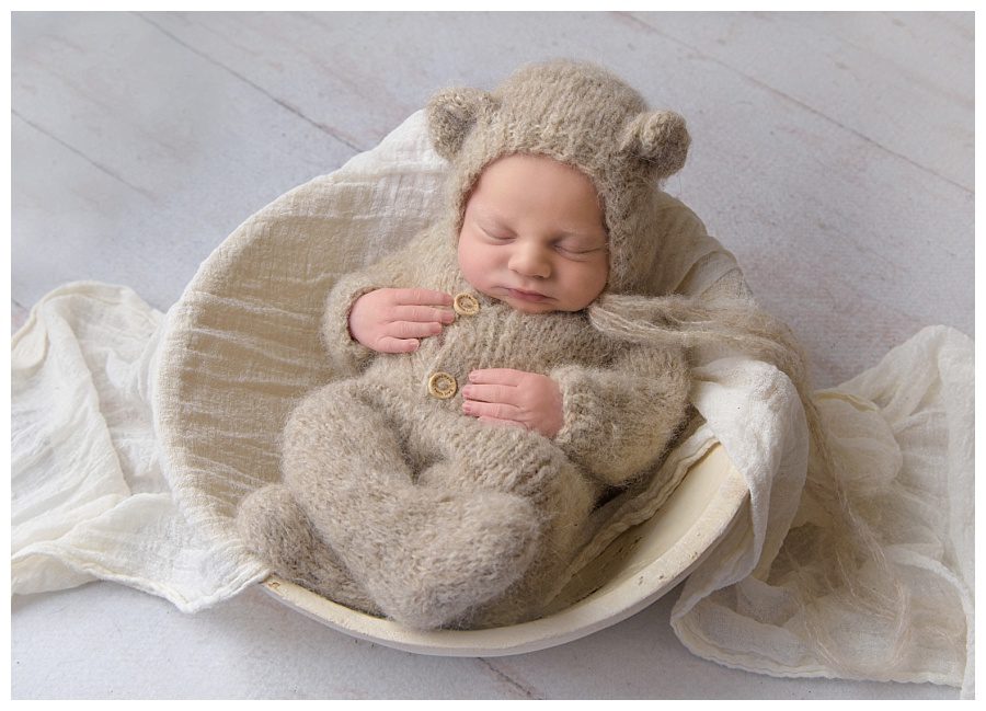 baby boy in knitted romper and teddy hat