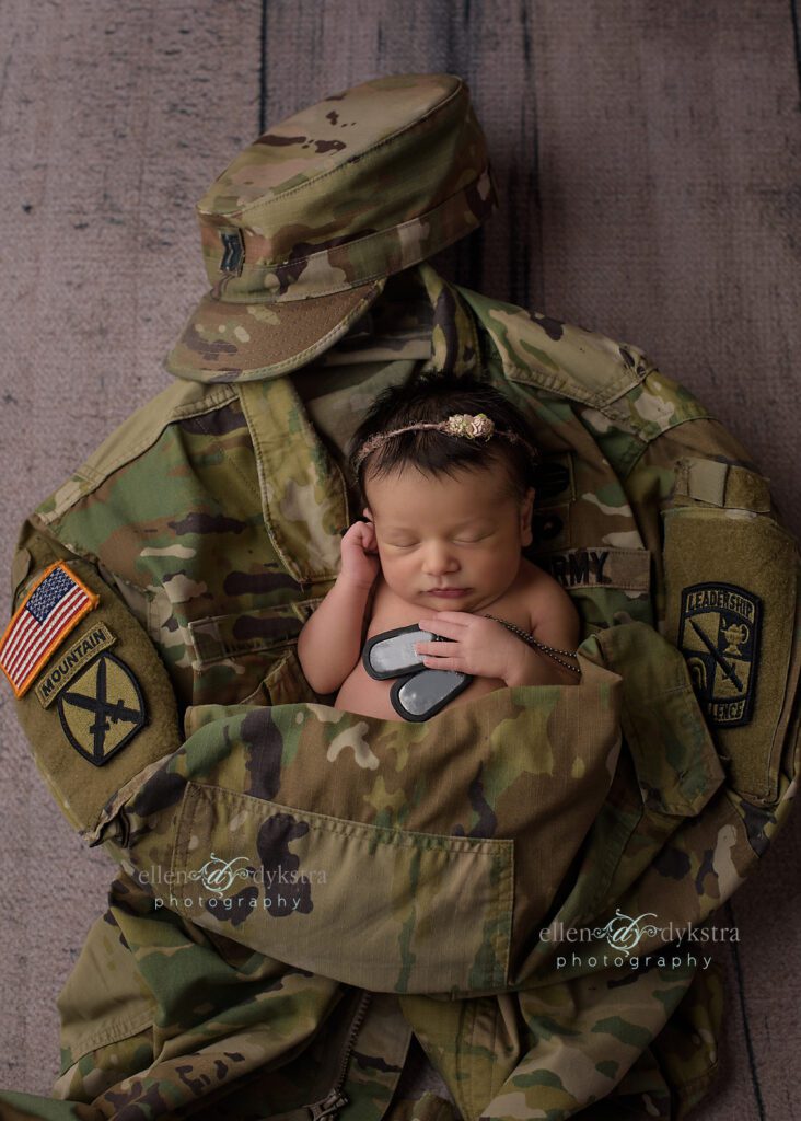 newborn baby with dad's army uniform