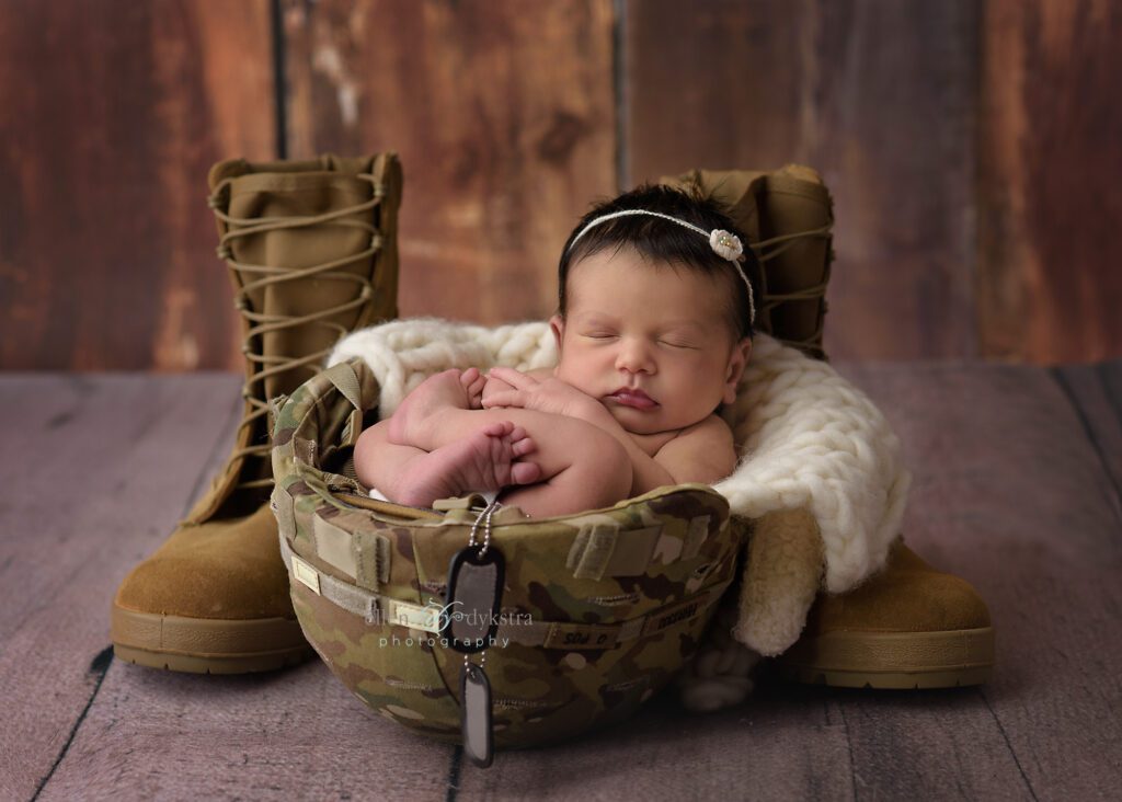 newborn baby in dad's army helmet