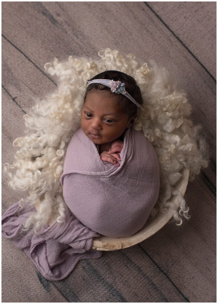 baby in lavender wrap in round bowl